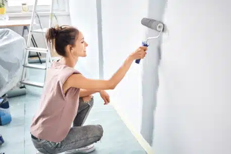 Woman painting wall with paint roller