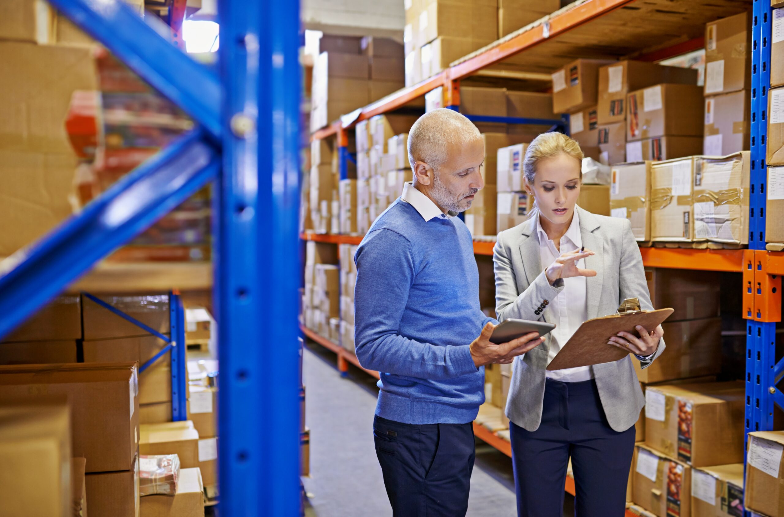 two businesspeople inspecting inventory in a warehouse