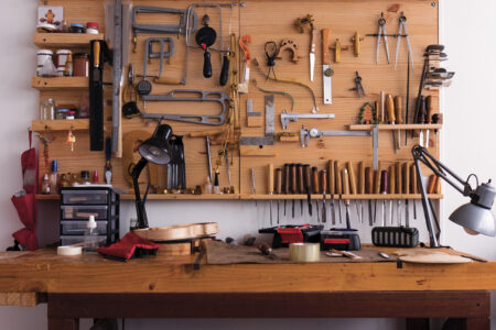 Workshop tools hung on a pegboard next to a desk
