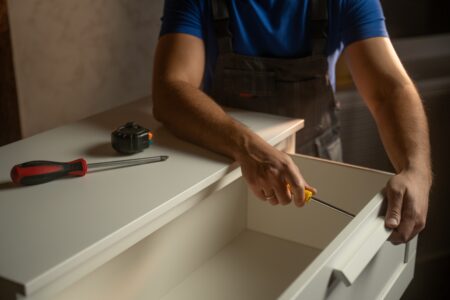 A man fixing a cabinet with tools for woodworking storage