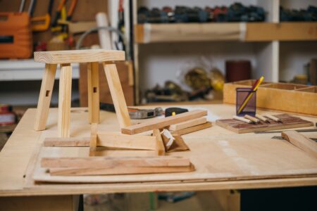 A woodworking workbench with a wooden chair being worked on