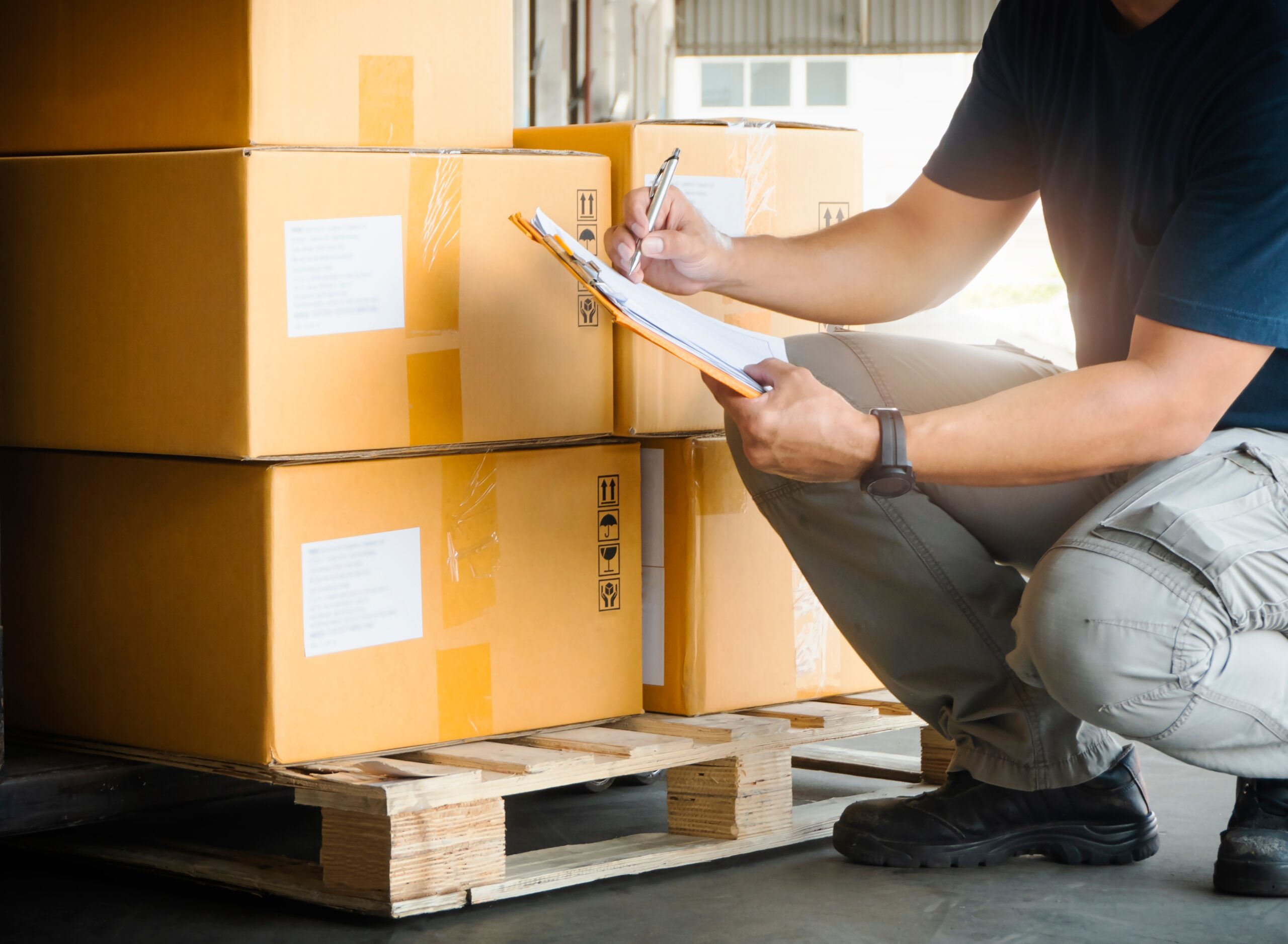 A man taking inventory of items in cardboard boxes before storage