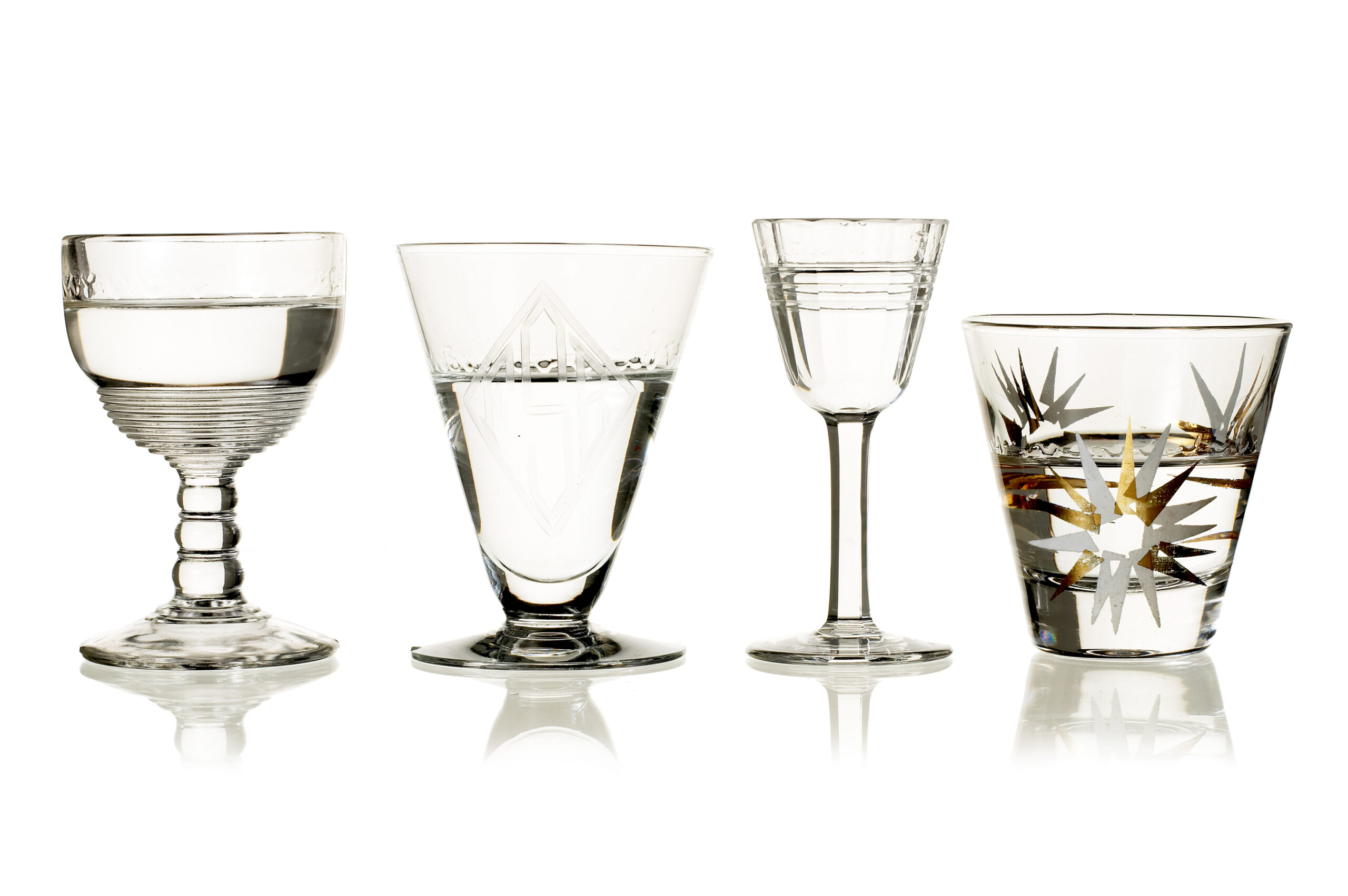 front view of four antique shot glasses