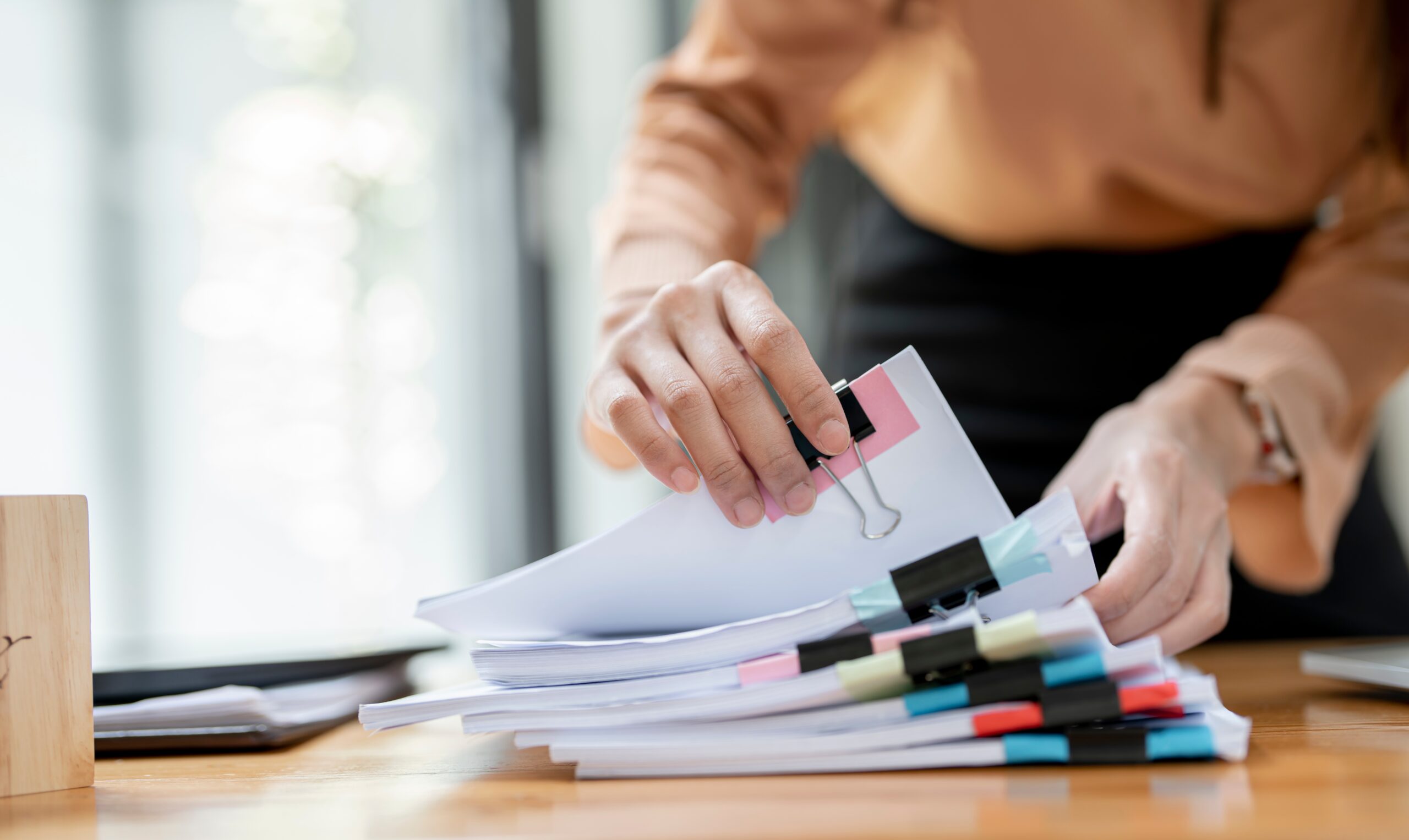 A woman looking through a stack of permits and paperwork