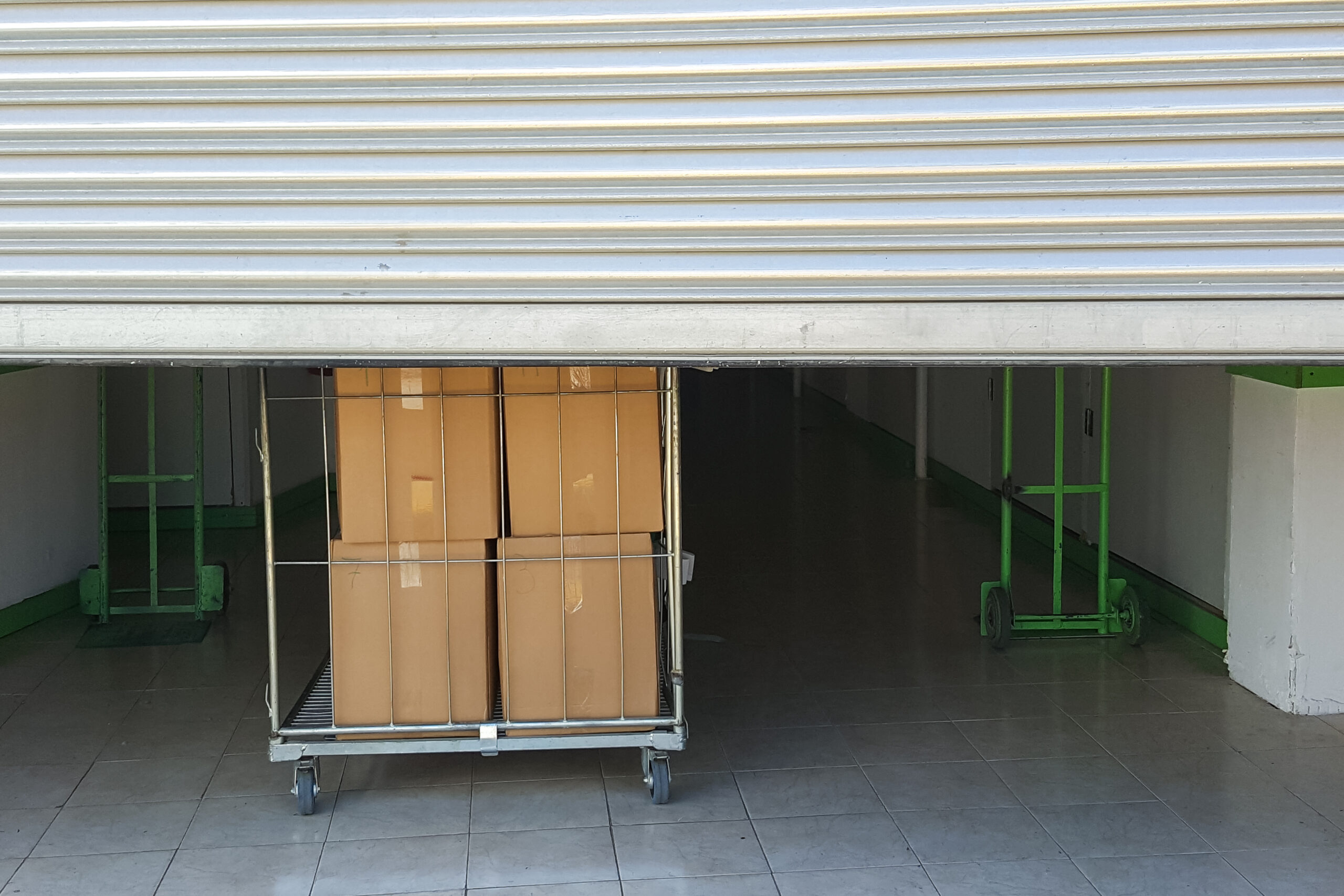 Half-opened maxi storage unit with boxes and trolleys