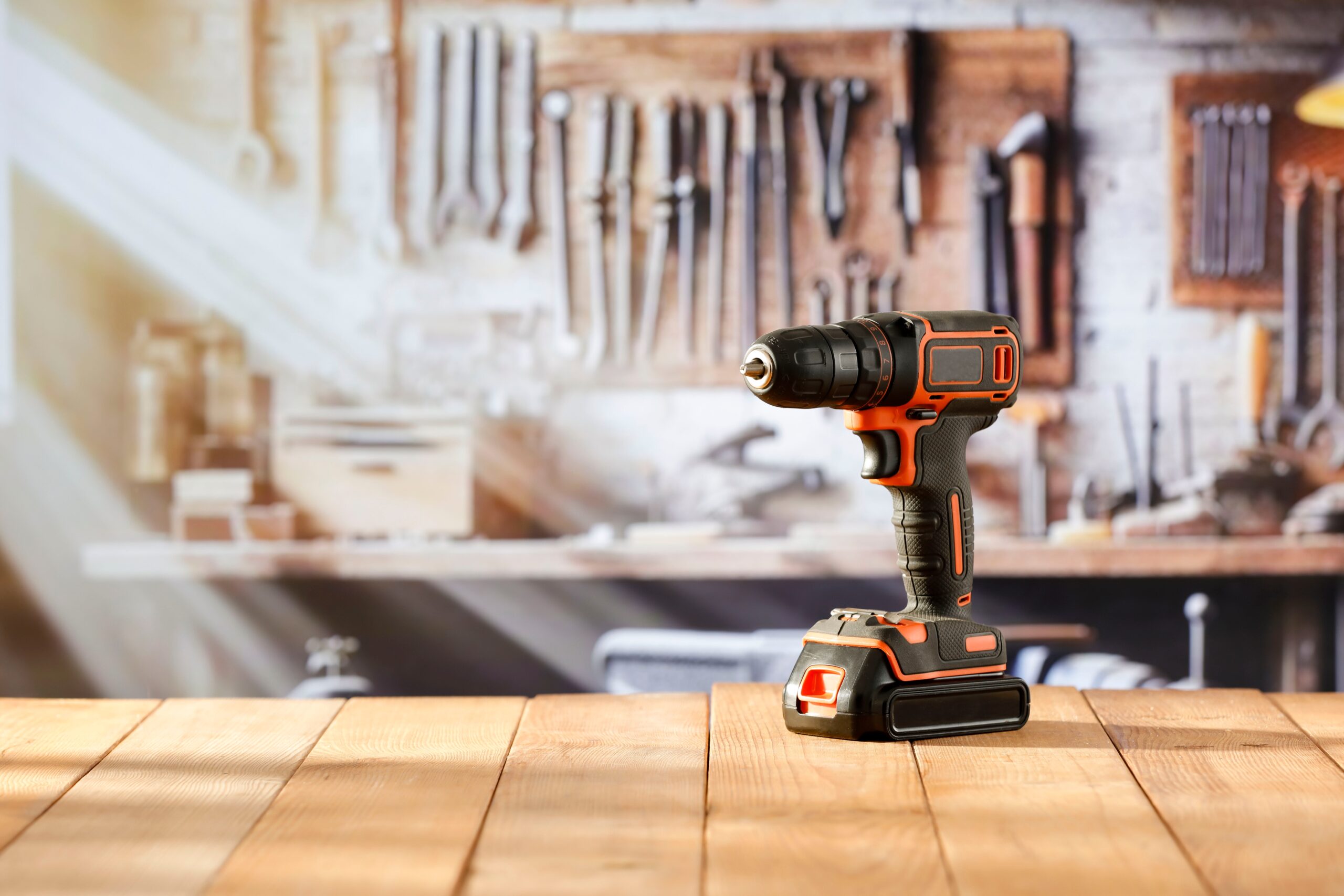 cordless drill screwdriver tool on wooden work table in craft workshop